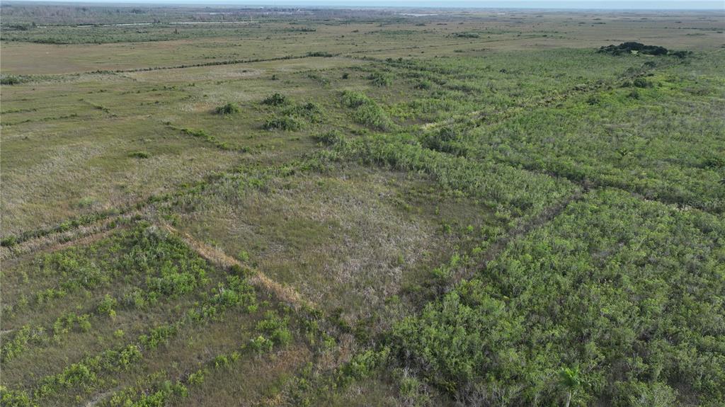An aerial view of a large, undeveloped plot of land featuring grassy fields and shrubs — SOUTHWEST 382ND STREET, HOMESTEAD, FL