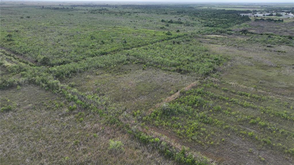 An aerial view shows a large, undeveloped plot of land with patches of low-lying vegetation — SOUTHWEST 382ND STREET, HOMESTEAD, FL
