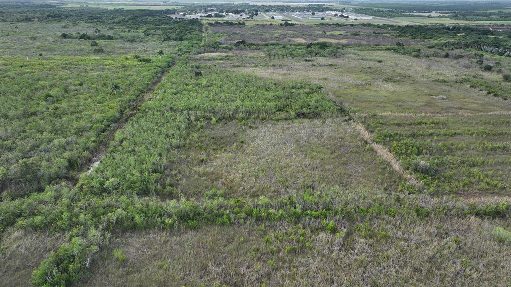 An aerial view shows a large, undeveloped plot of land covered in grass and shrubs — SOUTHWEST 382ND STREET, HOMESTEAD, FL