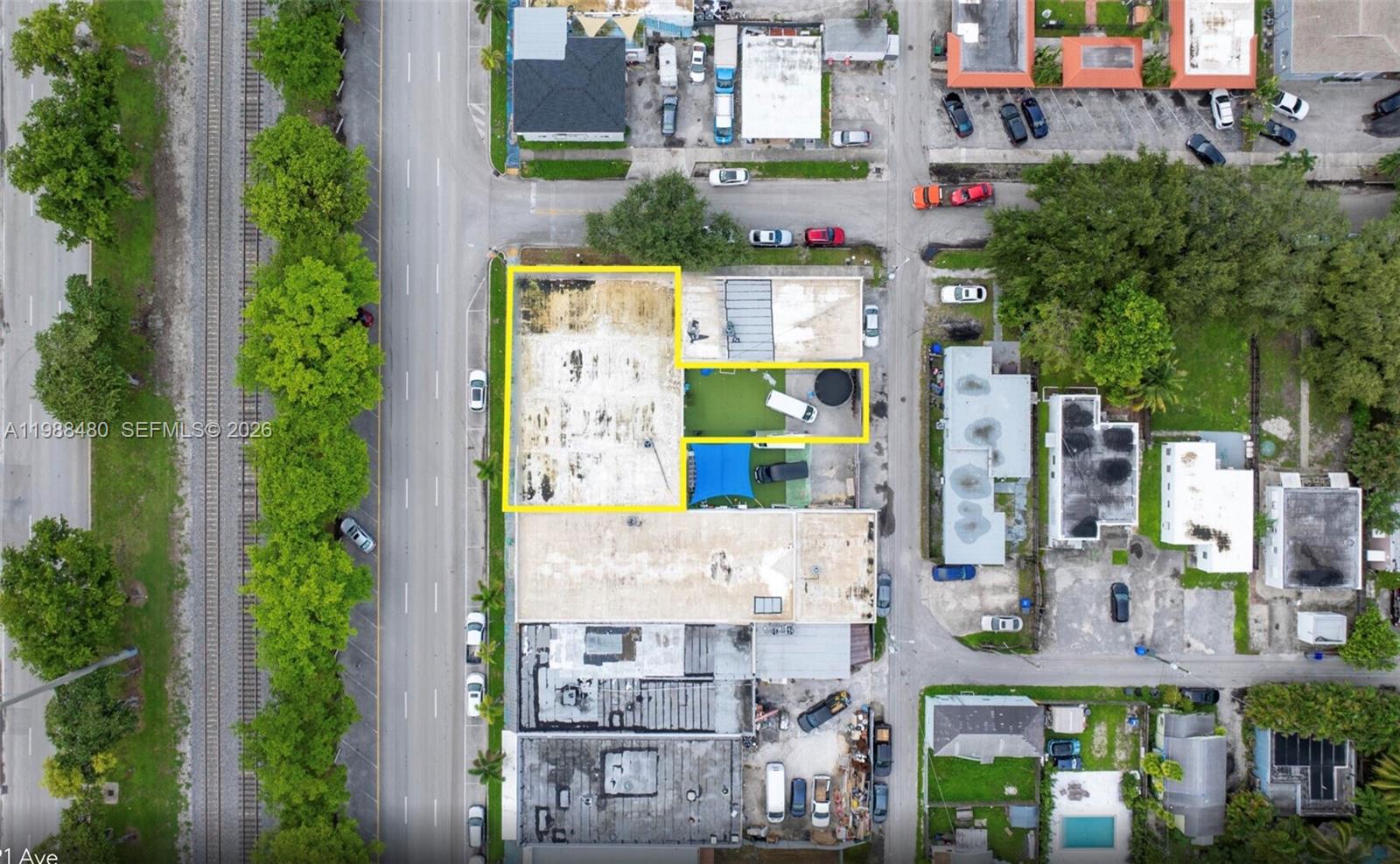This aerial view shows a commercial lot with a building and a fenced yard — 601 S 21st Ave, Hollywood FL 33020, HOLLYWOOD, FL