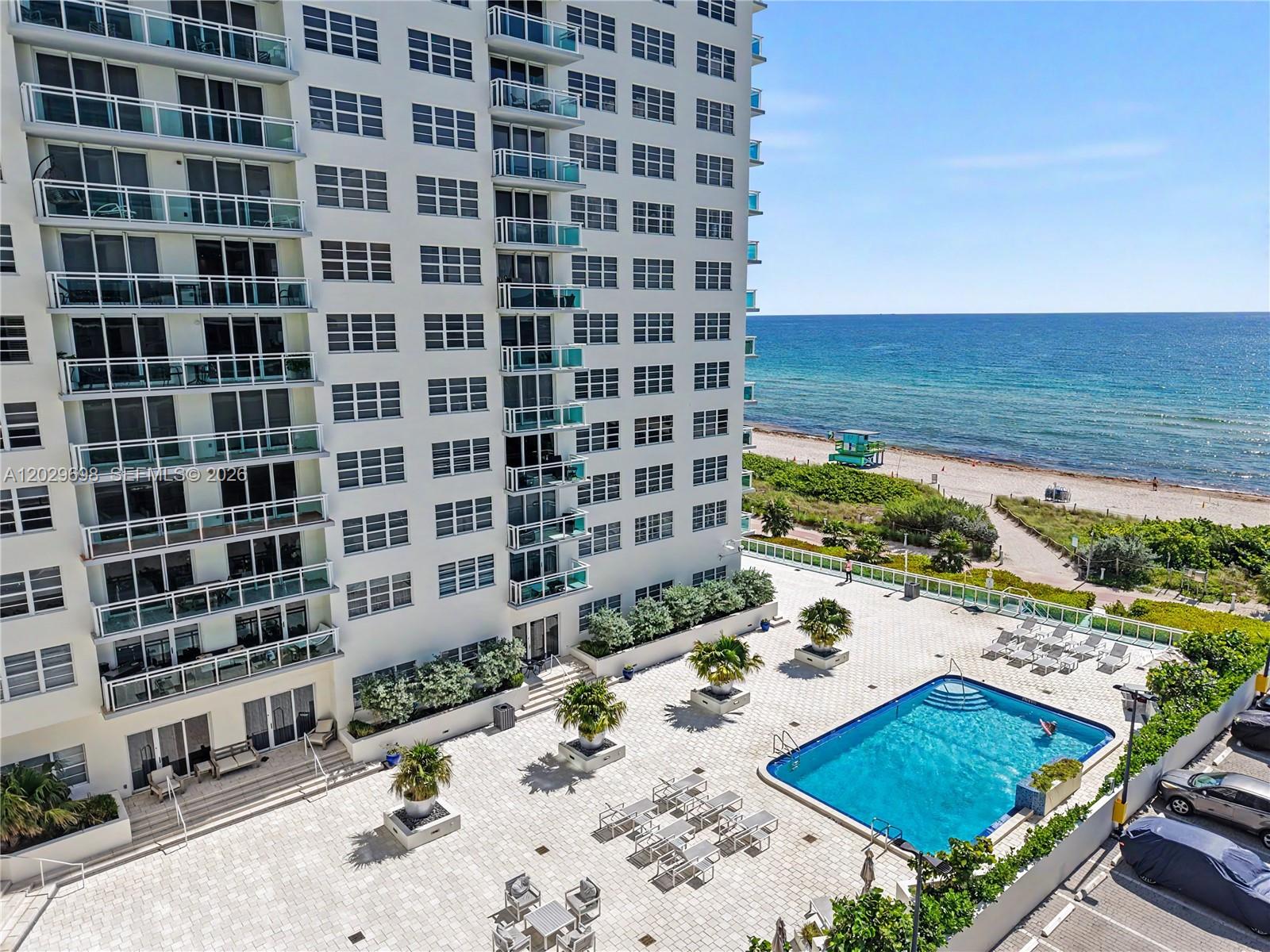 An aerial view of a high-rise building with a pool deck overlooking the ocean — 6917 Collins Ave # 605, Miami Beach FL 33141, MIAMI BEACH, FL