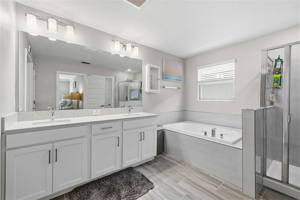 A bathroom with a double vanity, a soaking tub, and a glass-enclosed shower — 2920 GRIDIRON ISLE, NEW PORT RICHEY, FL