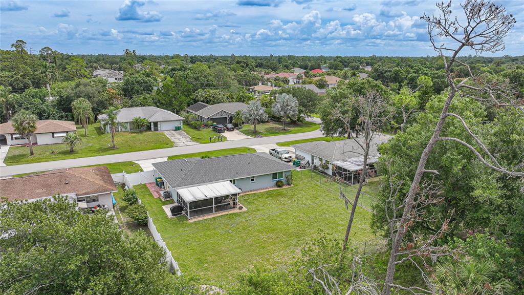 An aerial view shows a residential neighborhood with single-story houses, green lawns, and mature trees — 20341 XITA AVENUE, PORT CHARLOTTE, FL
