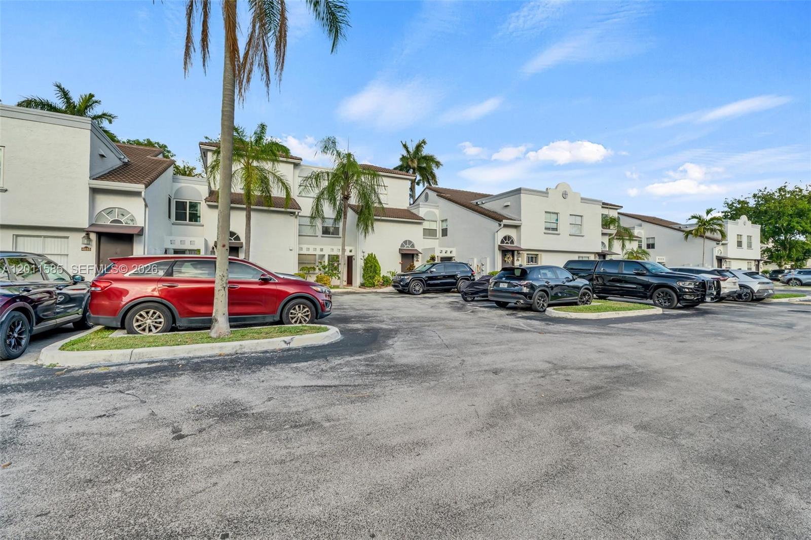 A parking lot sits in front of a row of multi-story residential townhouses — 4647 NW 97th Pl # 151, Doral FL 33178, DORAL, FL