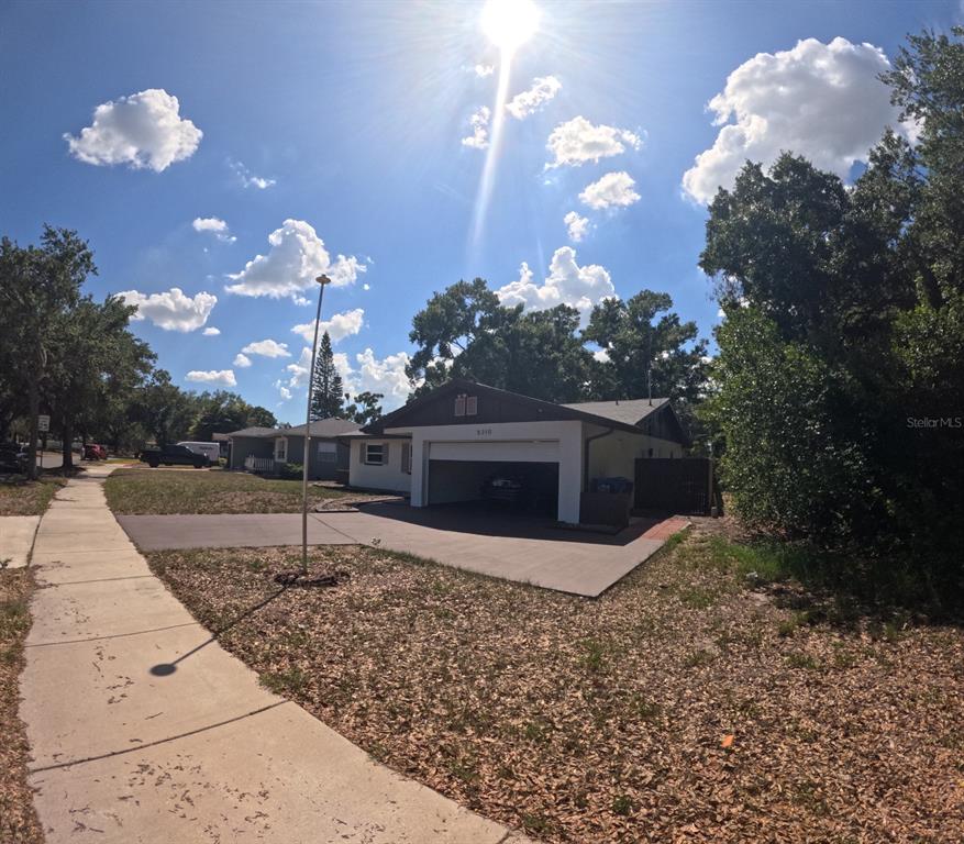 A single-story house with a carport and a concrete driveway under a sunny sky — 5210 DR MARTIN LUTHER KING JR ST N STREET, ST PETERSBURG, FL