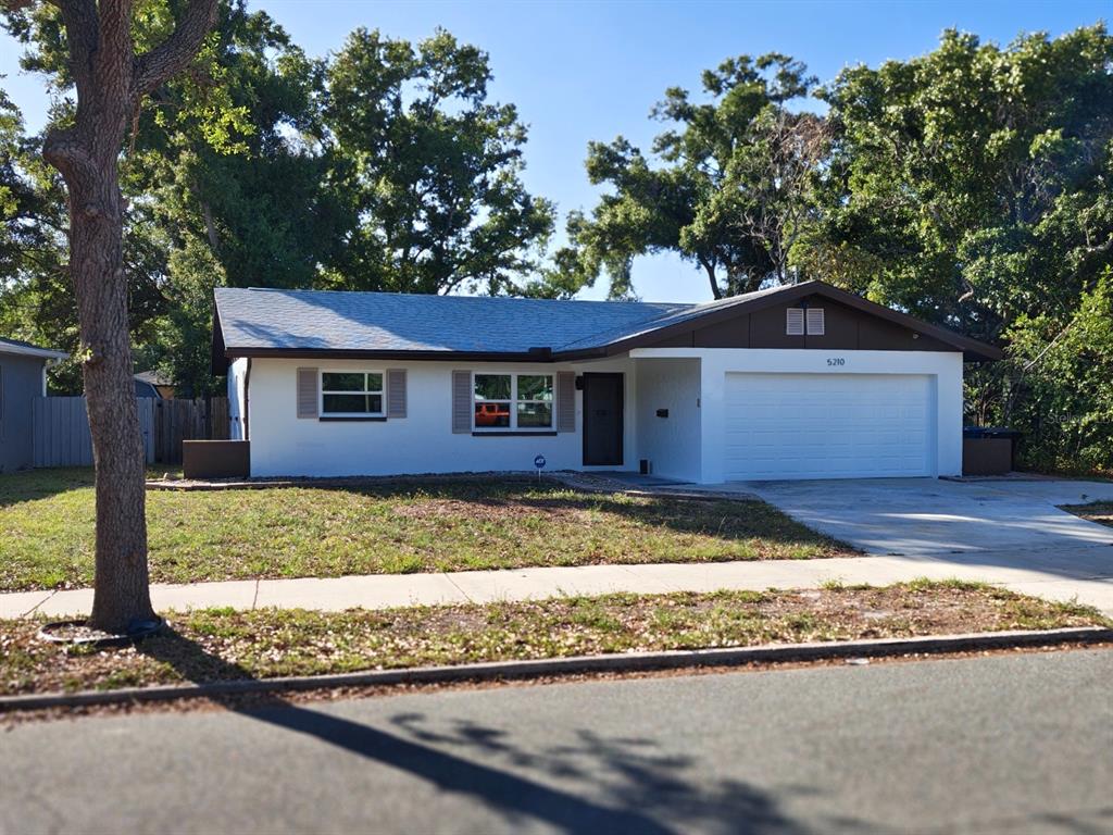 A single-story house with a white exterior, brown trim, and an attached two-car garage — 5210 DR MARTIN LUTHER KING JR ST N STREET, ST PETERSBURG, FL