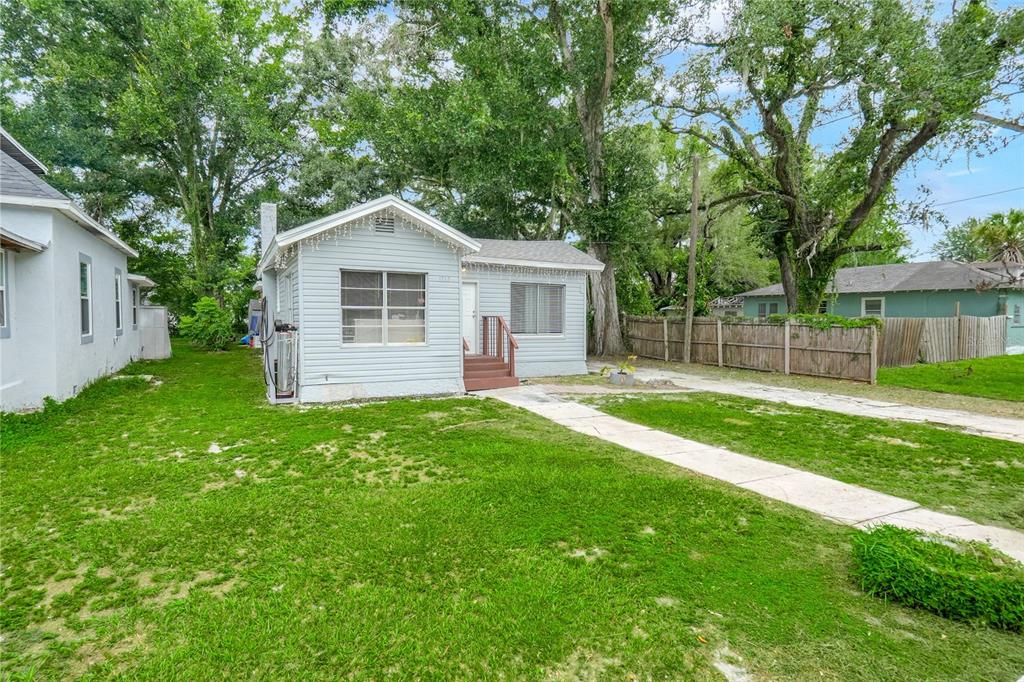 A light blue single-story house with a front walkway and a wooden entrance staircase — 1313 4TH STREET NE, WINTER HAVEN, FL