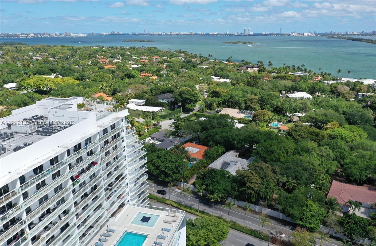 An aerial view shows a high-rise building with a pool deck overlooking a coastal neighborhood — 4250 Biscayne Blvd # 1115, Miami FL 33137, MIAMI, FL