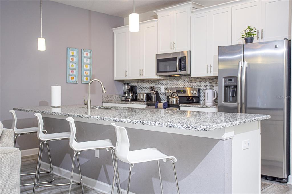 A screened-in patio features a swimming pool with an inflatable orca and a grill area — 3078 JULIET DR, KISSIMMEE, FL