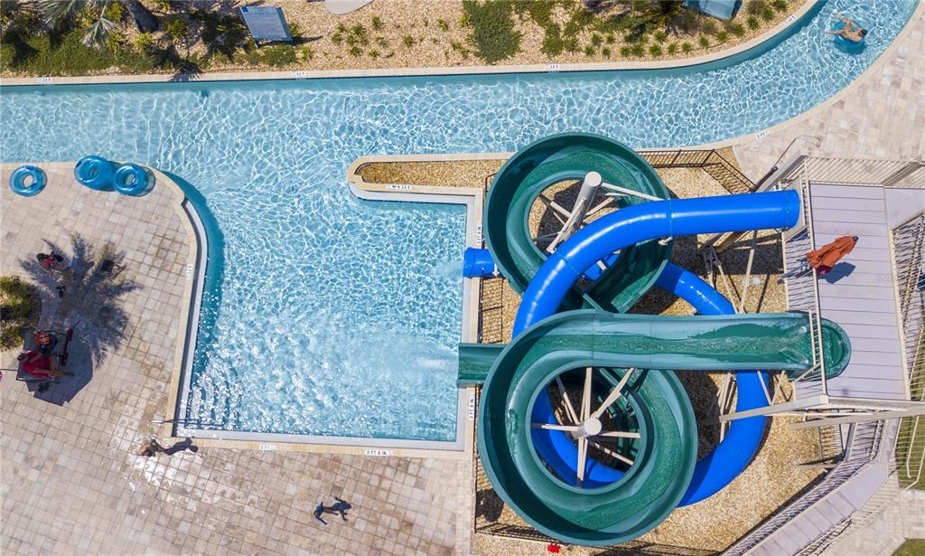 An aerial view shows a swimming pool with a lazy river and two water slides — 3078 JULIET DR, KISSIMMEE, FL
