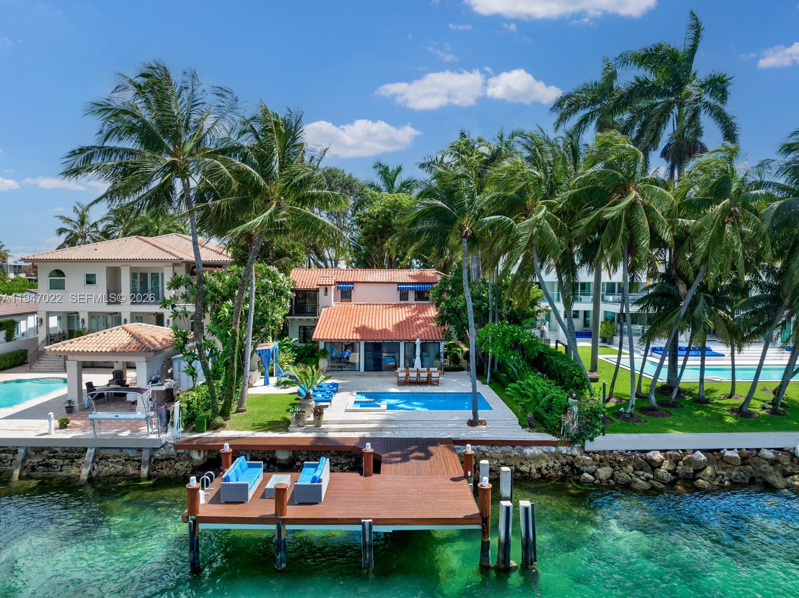 An aerial view of a waterfront house with a pool, dock, and palm trees — 56 S Hibiscus Dr, Miami Beach FL 33139, MIAMI BEACH, FL