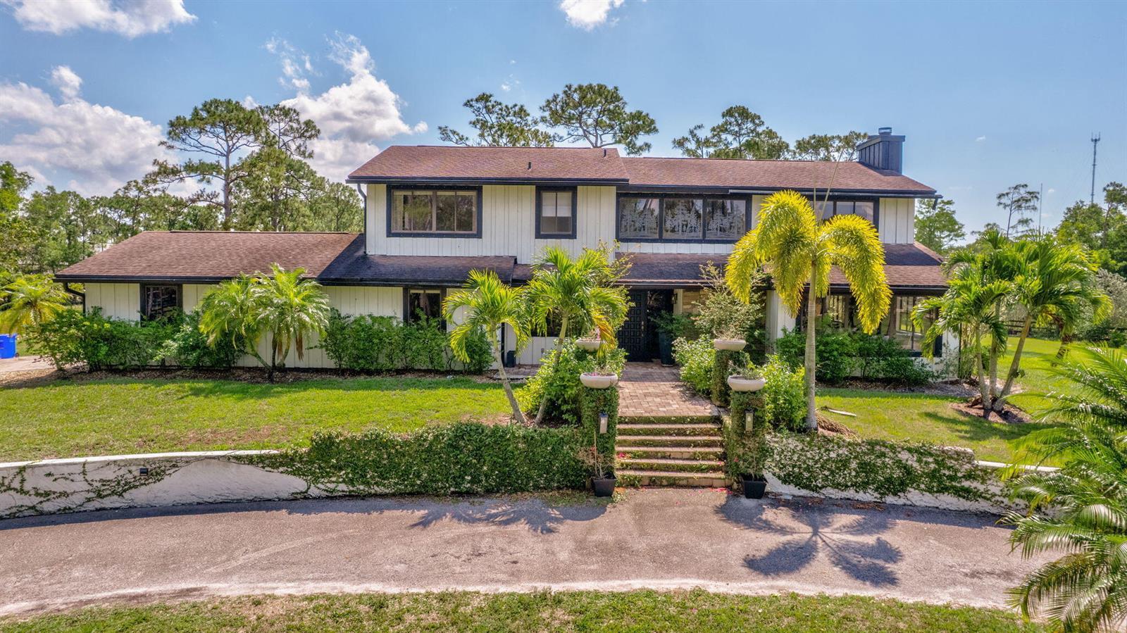 A two-story house with white siding, a dark roof, and a brick walkway with stairs — 5446 Reynolds Road, Lake Worth FL 33449, LAKE WORTH, FL