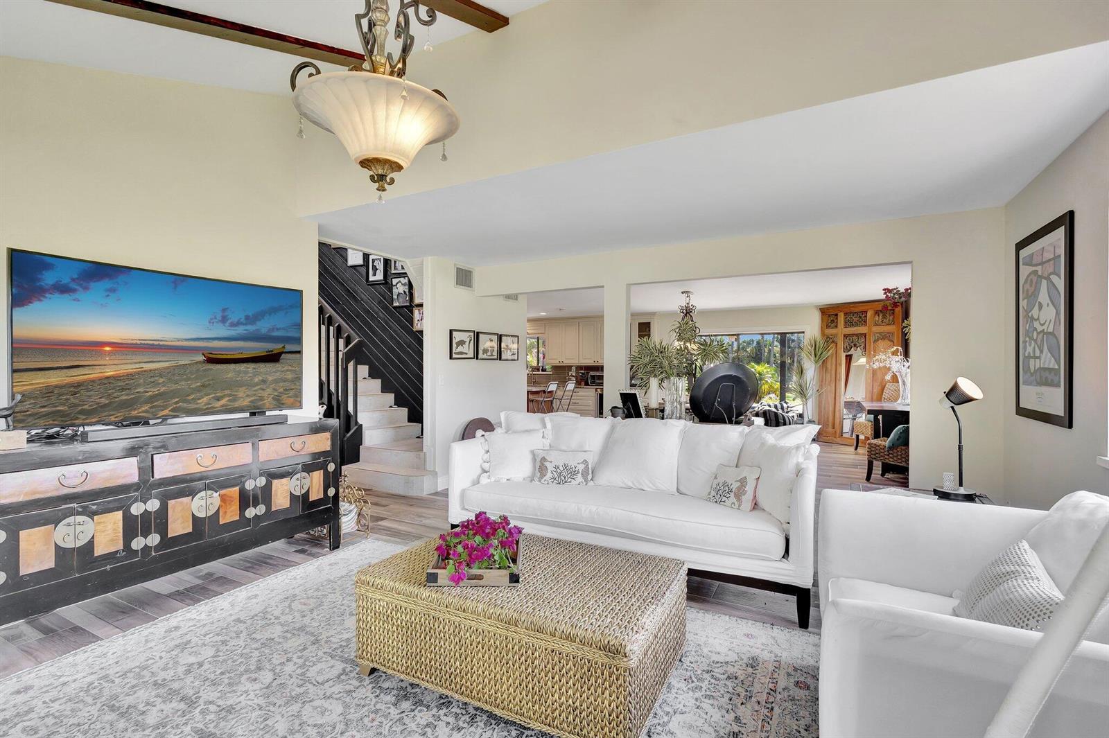 A living room features a white sofa, a woven ottoman, and a staircase with railings — 5446 Reynolds Road, Lake Worth FL 33449, LAKE WORTH, FL
