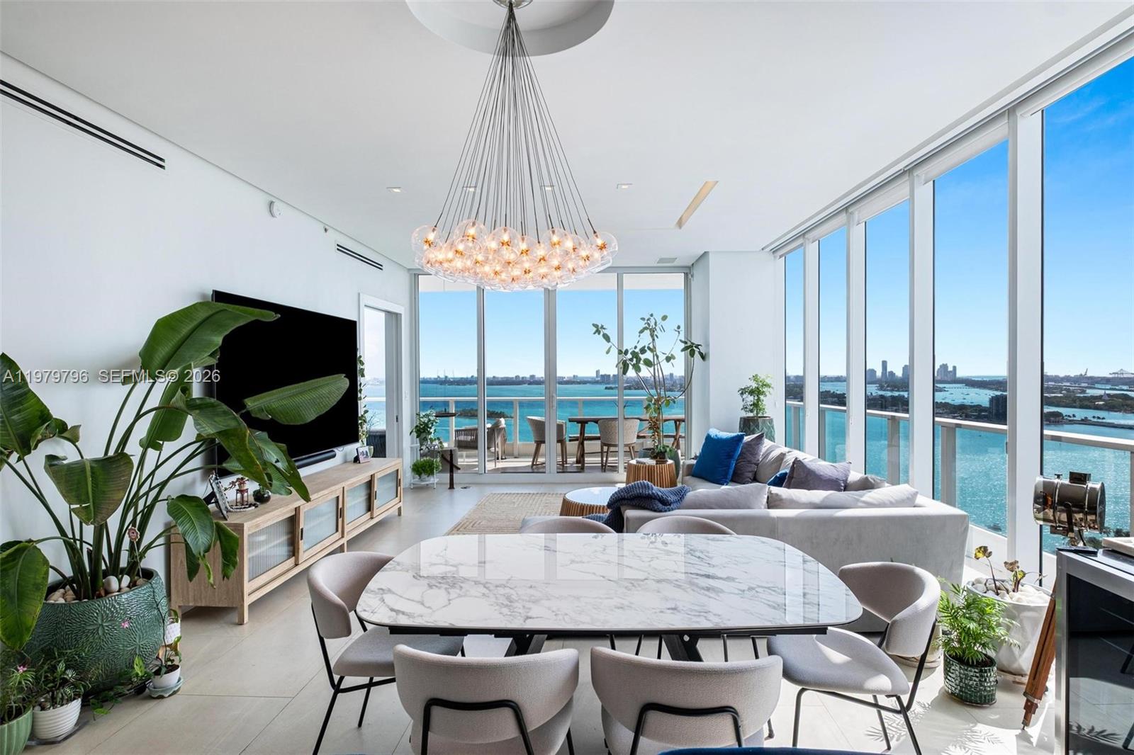 A modern living and dining area features floor-to-ceiling windows with expansive ocean views — 2020 N Bayshore Dr # 2510, Miami FL 33137, MIAMI, FL