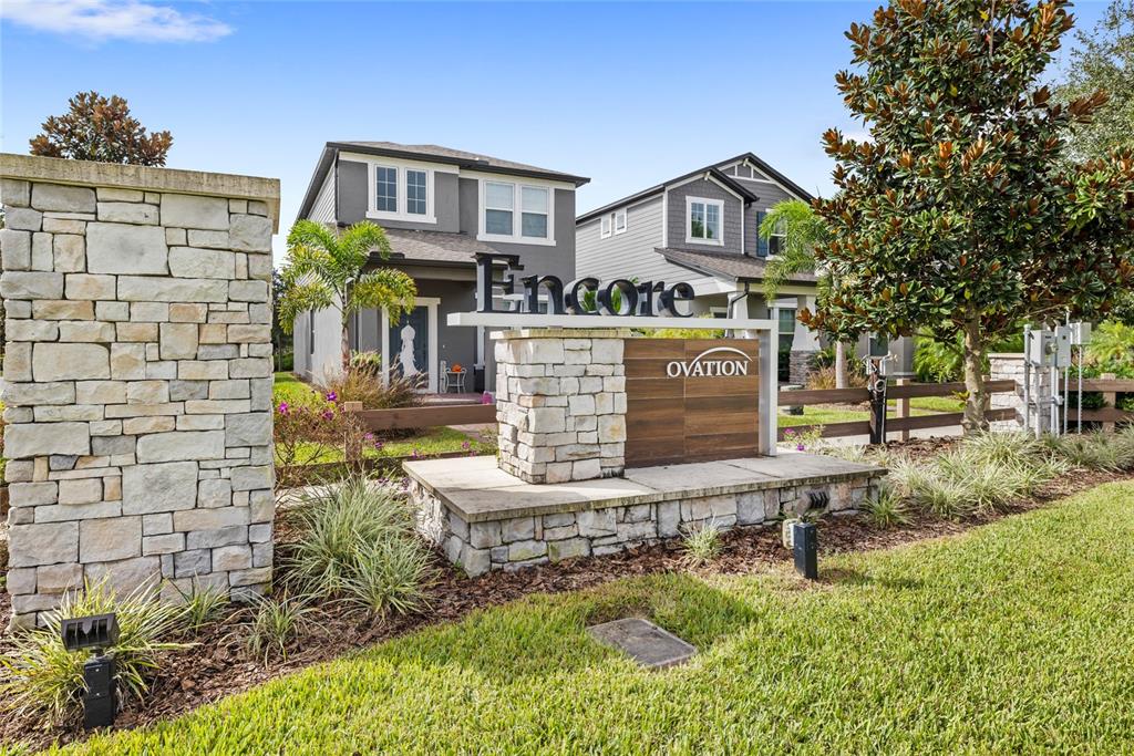 A stone monument sign for Encore at Ovation stands in front of two suburban houses — 12410 ENCORE AT OVATION WAY, WINTER GARDEN, FL