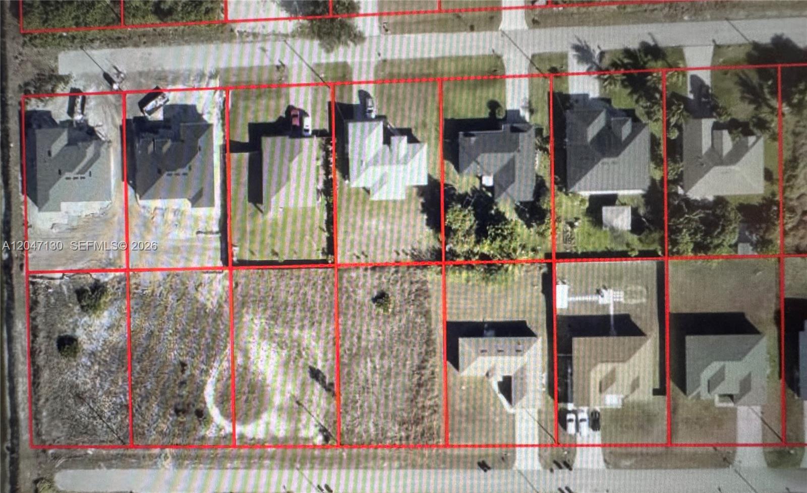 This aerial view shows several residential lots, some with houses and others that are vacant — 3816 35, Lehigh Acres FL 33976, LEHIGH ACRES, FL