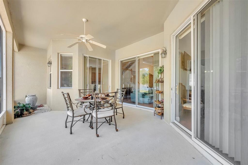 A covered patio features a dining set, a ceiling fan, and sliding glass doors — 5459 RISHLEY RUN WAY, MOUNT DORA, FL