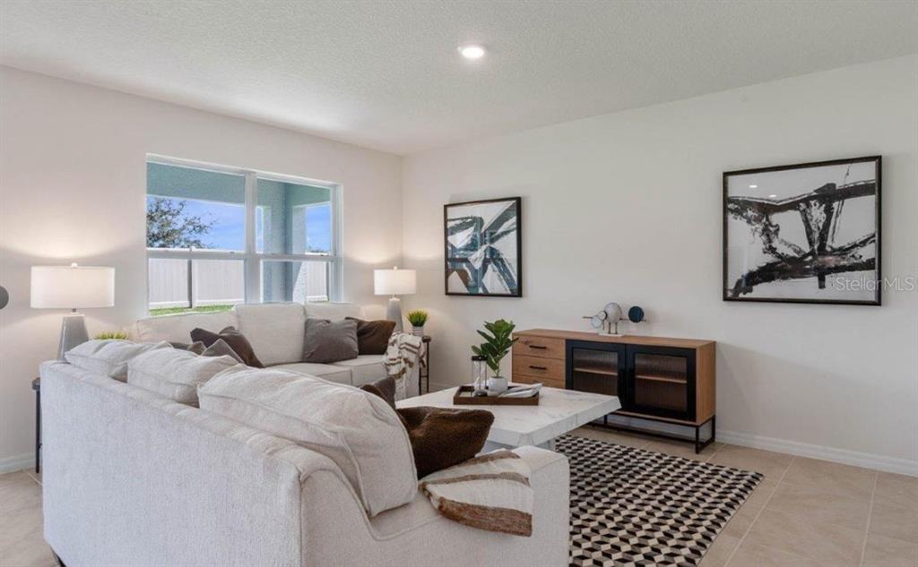 A living room features a white sofa, a marble coffee table, and a wooden media console — 1827 SILVERBELL LOOP, HAINES CITY, FL