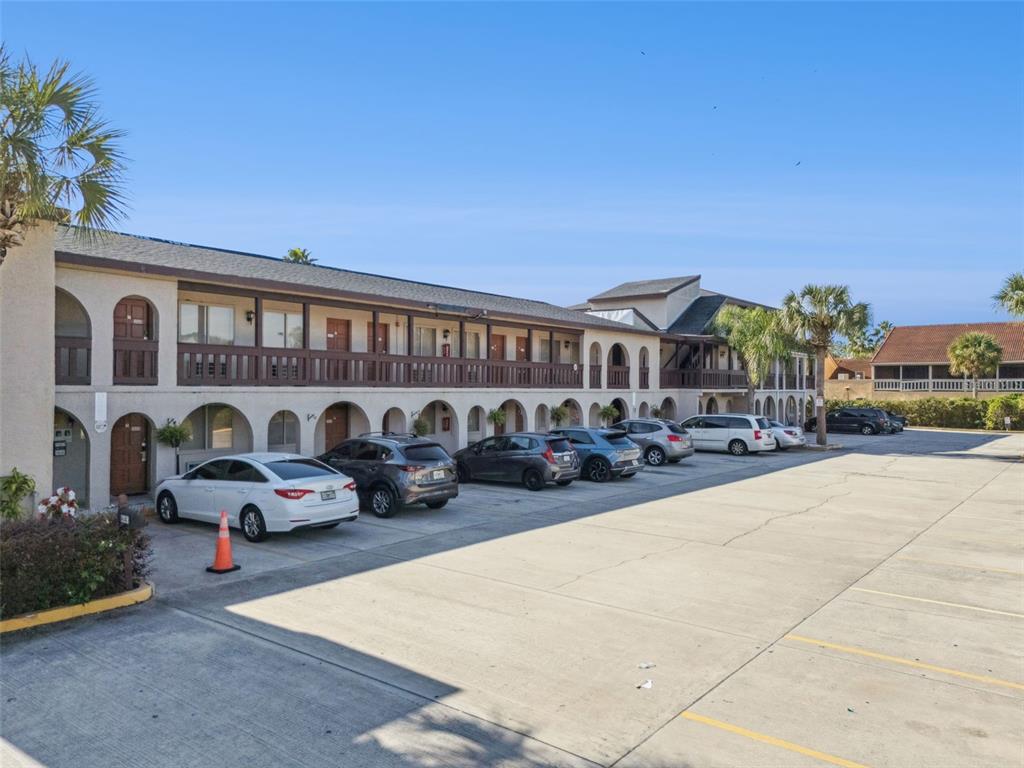 A two-story apartment building with arched entryways and a balcony overlooks a paved parking lot — 4640 W IRLO BRONSON MEMORIAL HIGHWAY, KISSIMMEE, FL