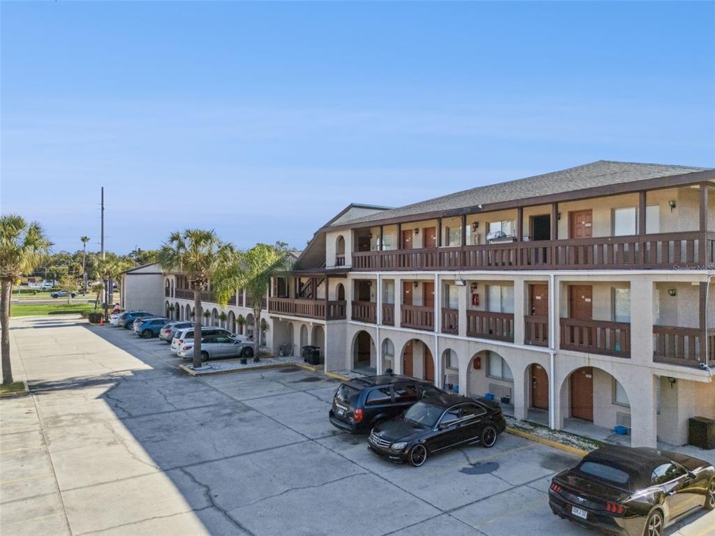 An exterior view of a multi-story apartment building with balconies and a parking lot — 4640 W IRLO BRONSON MEMORIAL HIGHWAY, KISSIMMEE, FL