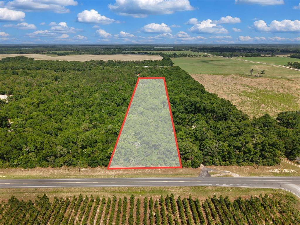 An aerial view shows a rectangular plot of land outlined in red along a road — Lot 3 N STATE RD 129, BRANFORD, FL