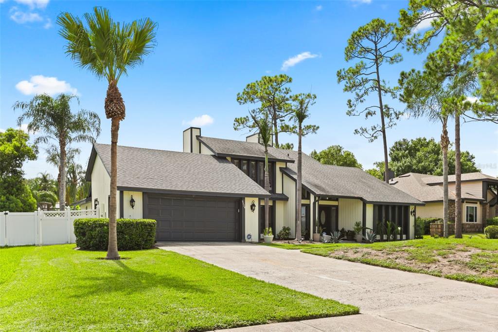 A two-story house with a dark garage door, light siding, and a concrete driveway — 9524 BAY VISTA ESTATES BOULEVARD, ORLANDO, FL