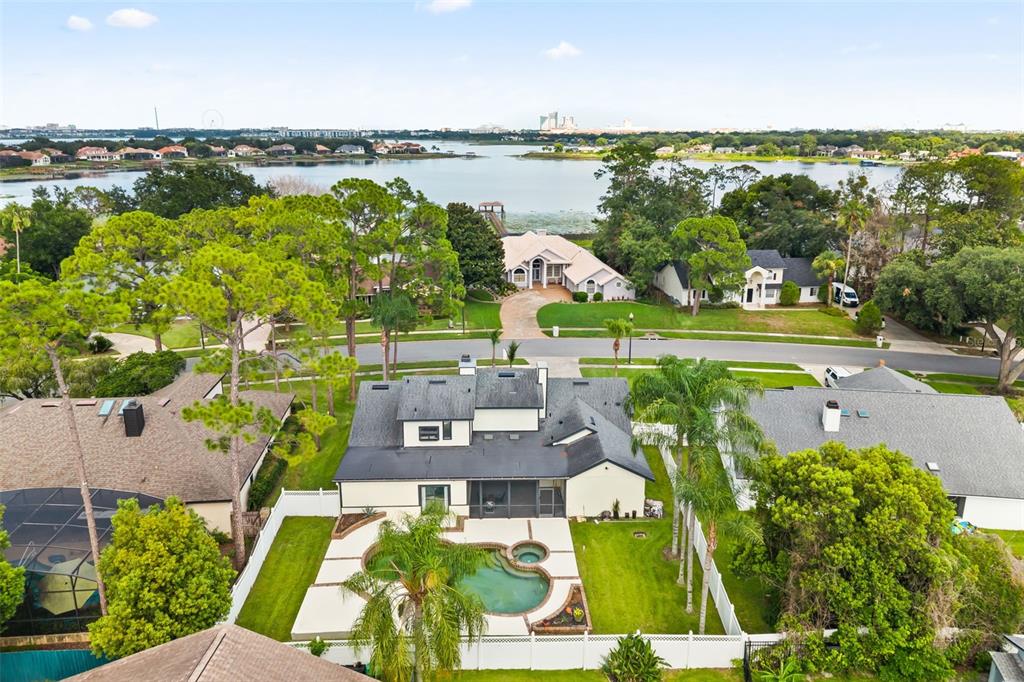 An aerial view shows a two-story house with a swimming pool and a lake view — 9524 BAY VISTA ESTATES BOULEVARD, ORLANDO, FL