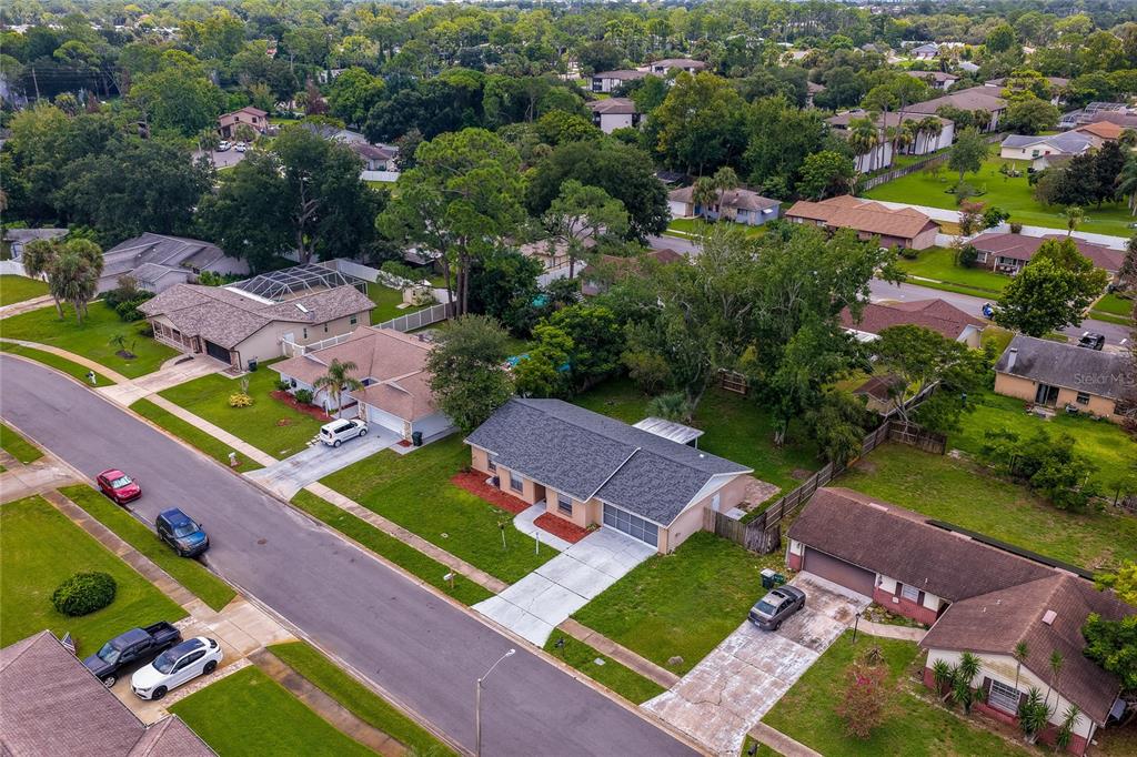 An aerial view of a suburban neighborhood featuring single-story houses with driveways and green lawns — 156 SPRINGWOOD DRIVE, DAYTONA BEACH, FL