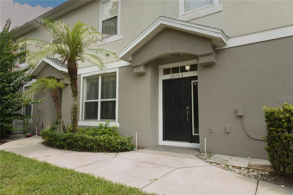 A two-story townhouse exterior features a black front door, a palm tree, and landscaping — 6438 S GOLDENROD ROAD UNIT 19A, ORLANDO, FL