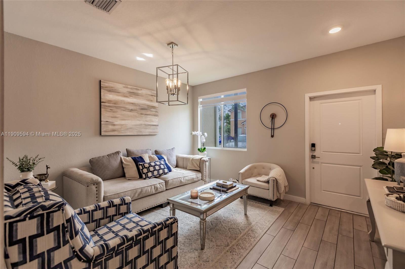 A living room features a sofa, patterned armchairs, a coffee table, and a front door — 2333 SE 10th St, Homestead FL 33035, HOMESTEAD, FL