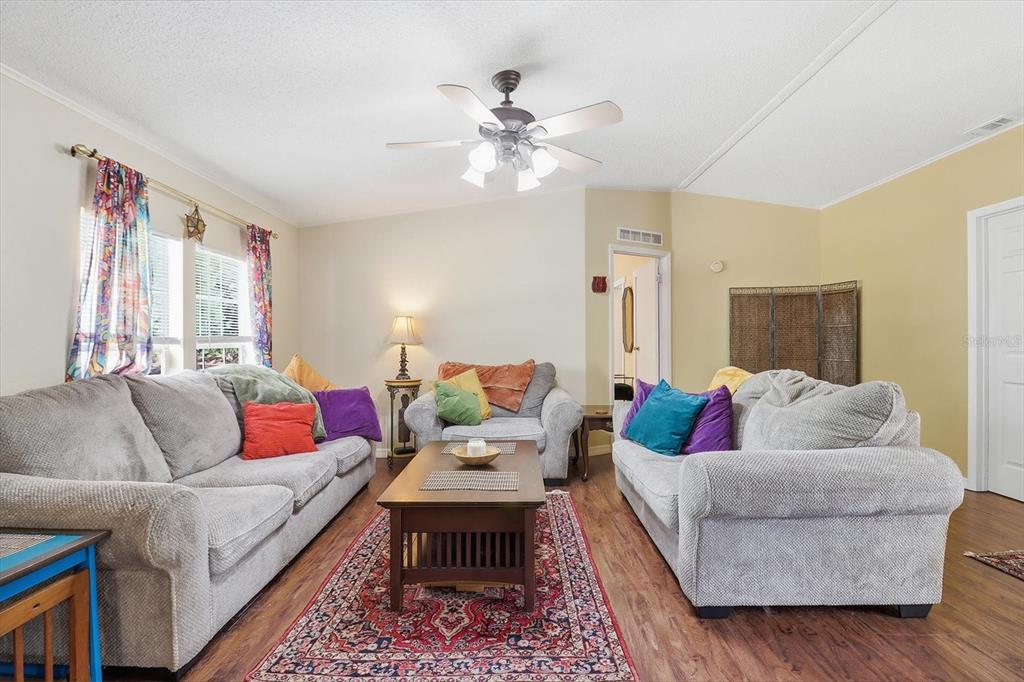 A living room features two grey sofas, a wooden coffee table, and a patterned rug — 4950 W MOCKINGBIRD STREET, HOMOSASSA, FL