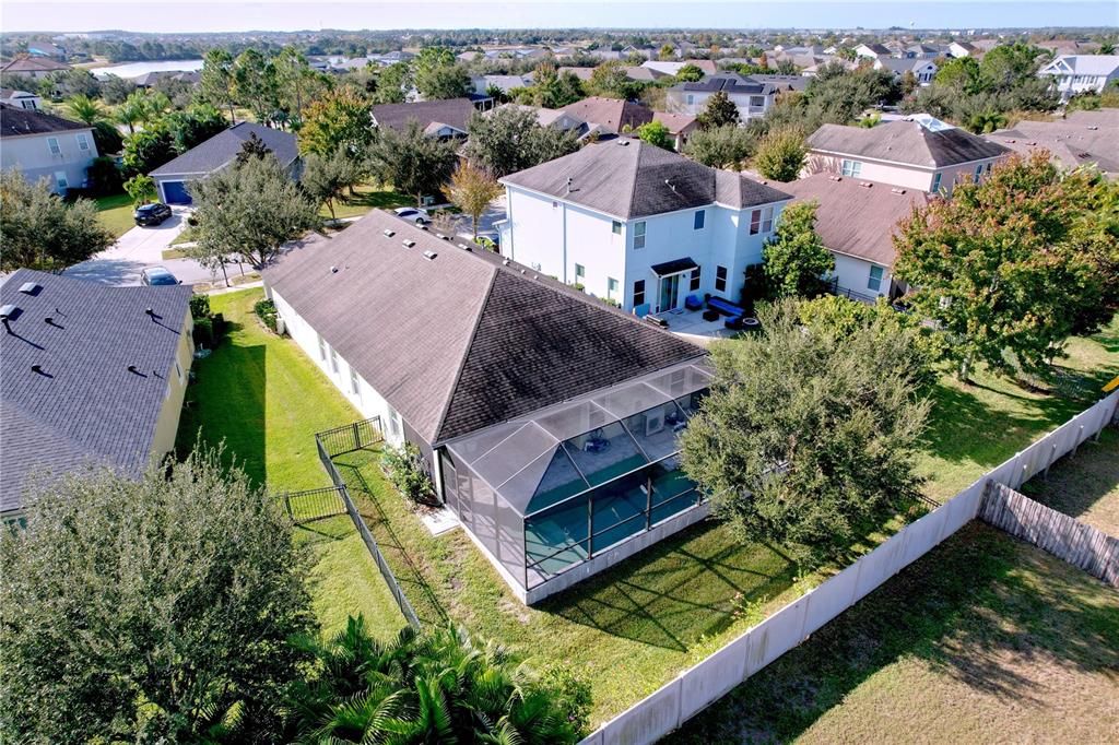 An aerial view shows a house with a screened-in pool and a fenced backyard — 6507 NESTALL COURT, APOLLO BEACH, FL