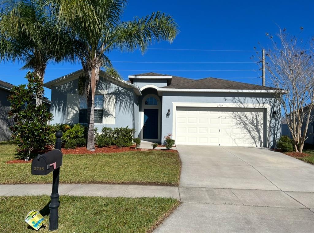 A single-story house with a blue exterior, a two-car garage, and a palm tree — 2735 CARRICKTON CIRCLE, ORLANDO, FL
