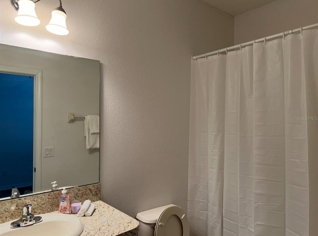 A bathroom features a vanity with a granite countertop, a mirror, and a shower curtain — 2735 CARRICKTON CIRCLE, ORLANDO, FL