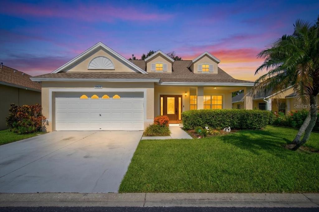 A single-story house with a two-car garage, dormer windows, and a landscaped front yard — 6615 SUMMER COVE DRIVE, RIVERVIEW, FL