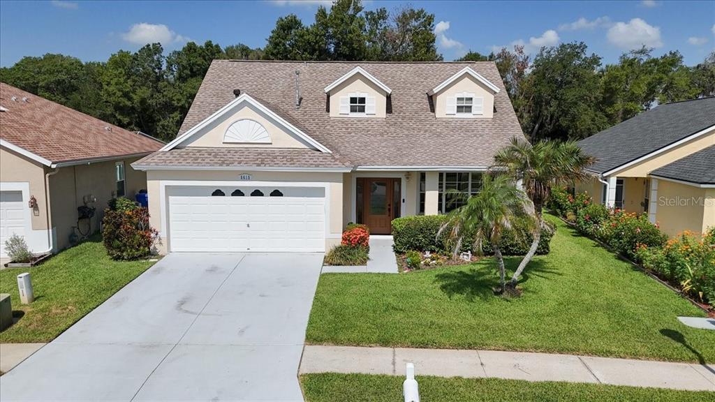 A two-story house with a white garage, tan siding, and a brown shingled roof — 6615 SUMMER COVE DRIVE, RIVERVIEW, FL
