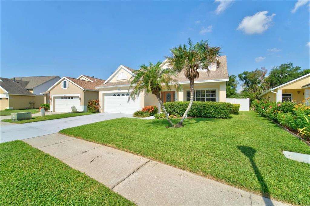 A single-story suburban house with a two-car garage, palm trees, and a manicured front lawn — 6615 SUMMER COVE DRIVE, RIVERVIEW, FL
