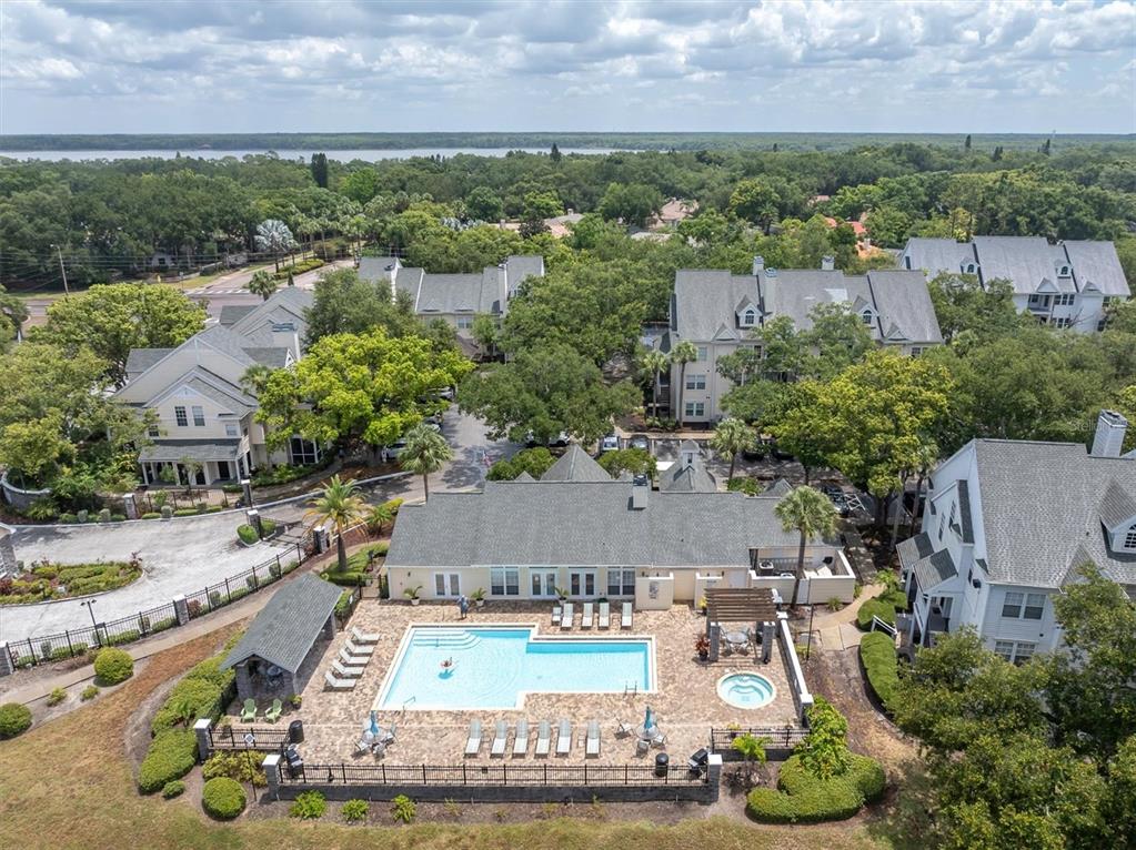An aerial view shows a swimming pool and hot tub at a multi-story apartment complex — 3313 HAVILAND COURT UNIT 203, PALM HARBOR, FL