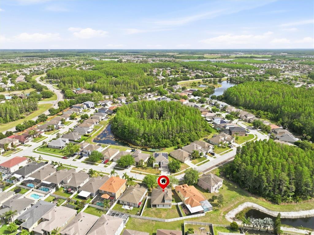 An aerial view shows a suburban neighborhood with a house marked by a red icon — 3036 GIANNA WAY, LAND O LAKES, FL