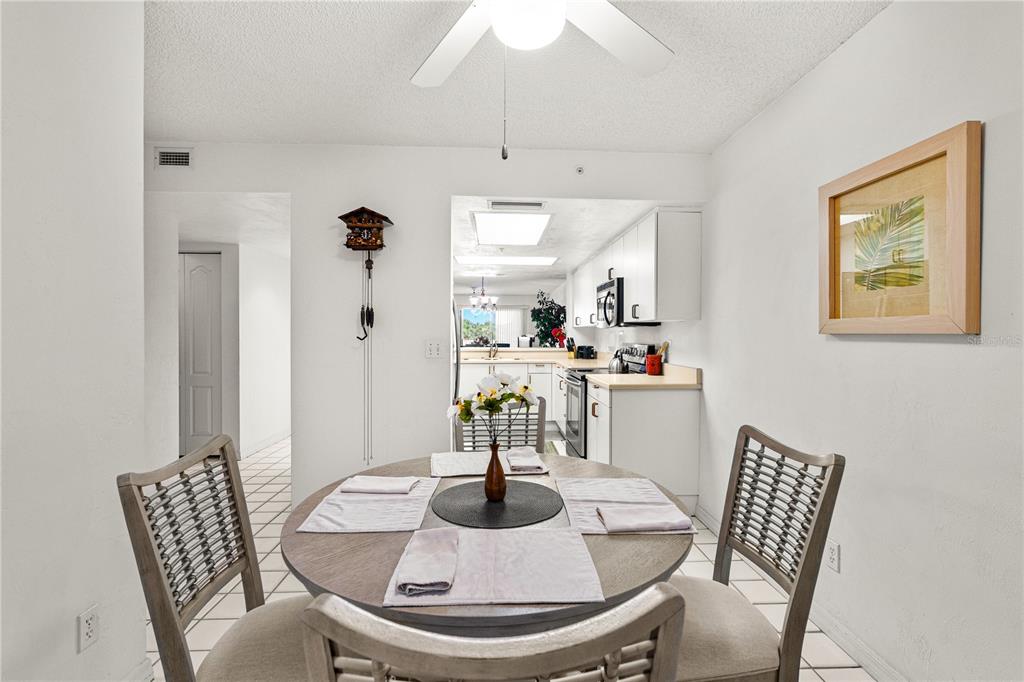 A balcony with a small table and chairs overlooks a lush green landscape and buildings — 3 OCEANS WEST BOULEVARD UNIT 3A7, DAYTONA BEACH SHORES, FL
