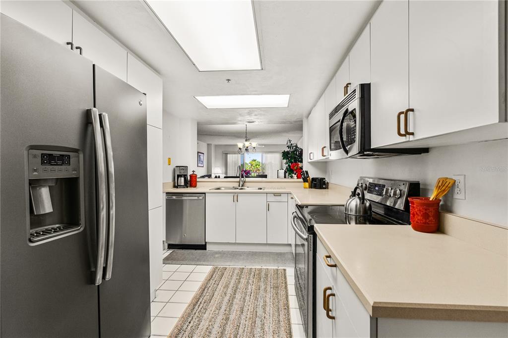 A living room features two black leather sofas, a striped ottoman, and a ceiling fan — 3 OCEANS WEST BOULEVARD UNIT 3A7, DAYTONA BEACH SHORES, FL