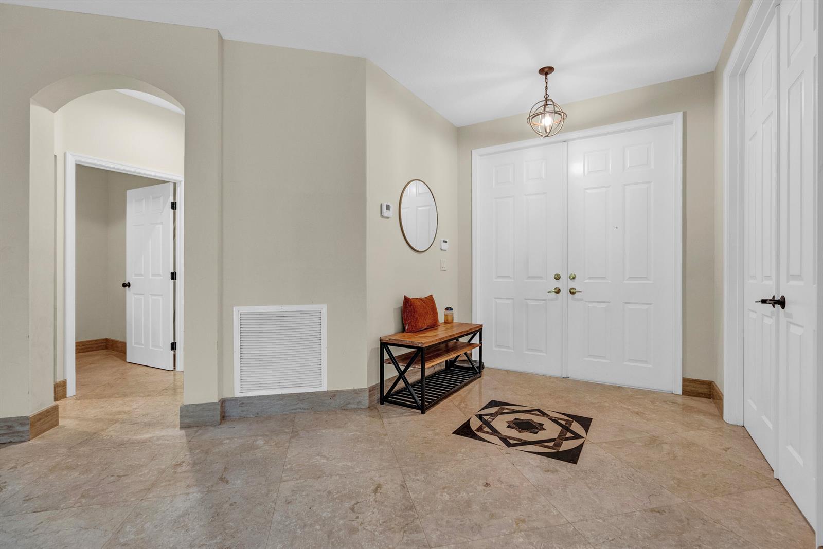 A tiled entryway features double front doors, a wooden bench, and an arched doorway — 2792 Shaughnessy Drive, Wellington FL 33414, WELLINGTON, FL