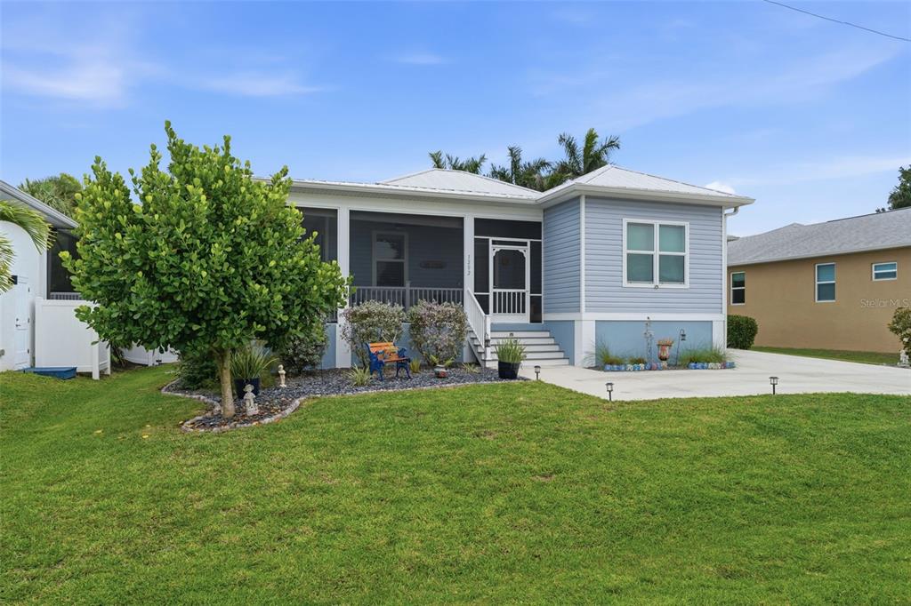 A light blue house with a screened front porch and a metal roof — 1202 MCGREGOR STREET, PUNTA GORDA, FL