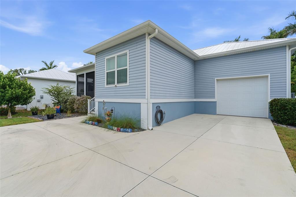 A light blue house with a white garage door and a concrete driveway — 1202 MCGREGOR STREET, PUNTA GORDA, FL