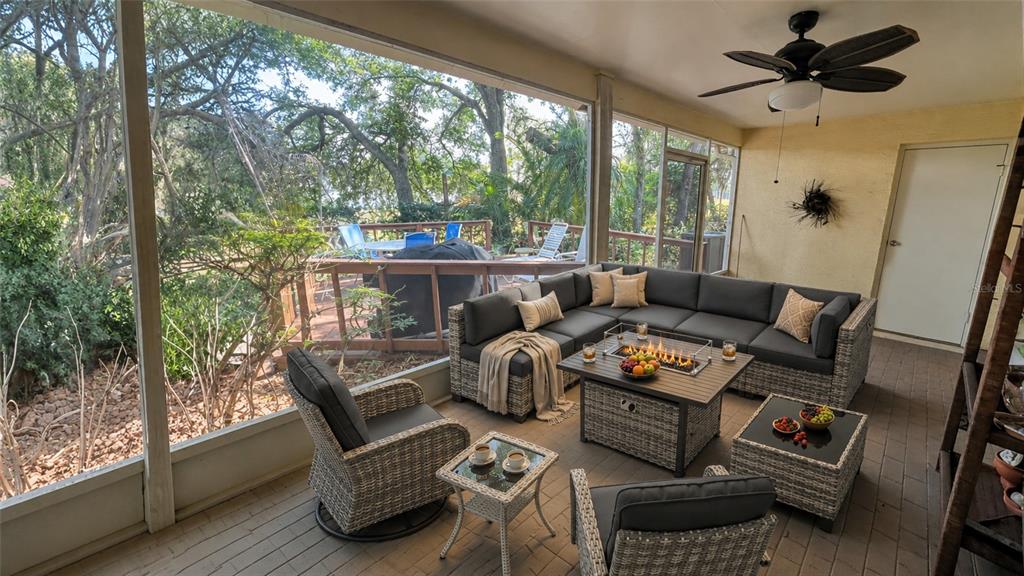 A screened-in patio features wicker furniture, a fire pit table, and a view of trees — 1320 SASSAFRAS AVENUE, ALTAMONTE SPRINGS, FL