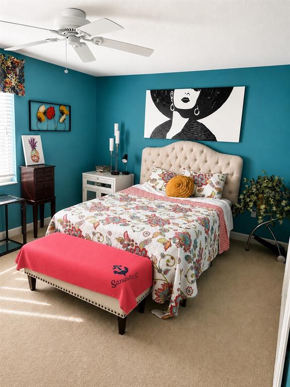 A bedroom features teal walls, a tufted headboard, a floral quilt, and a pink bench — 3720 EL POINIER COURT UNIT 515, SARASOTA, FL