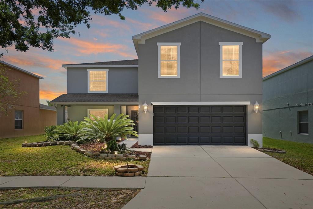 A two-story gray house with a two-car garage and a landscaped front yard — 30902 TEMPLE STAND AVENUE, WESLEY CHAPEL, FL