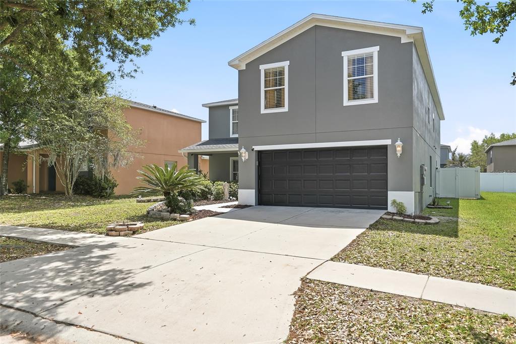 A two-story gray house with a two-car garage and a concrete driveway — 30902 TEMPLE STAND AVENUE, WESLEY CHAPEL, FL