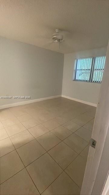An empty bedroom with light-colored tile flooring, a ceiling fan, and a window with blinds — 9943 Nob Hill Pl # 9943, Sunrise FL 33351, SUNRISE, FL