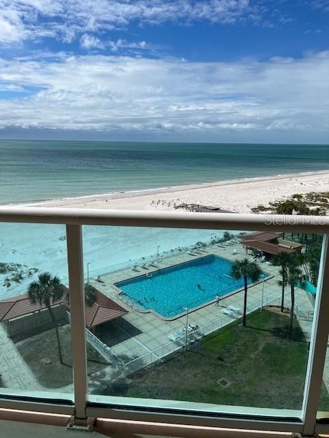 An elevated view shows a swimming pool, beach, and ocean from a balcony — 880 MANDALAY AVENUE UNIT S713, CLEARWATER BEACH, FL